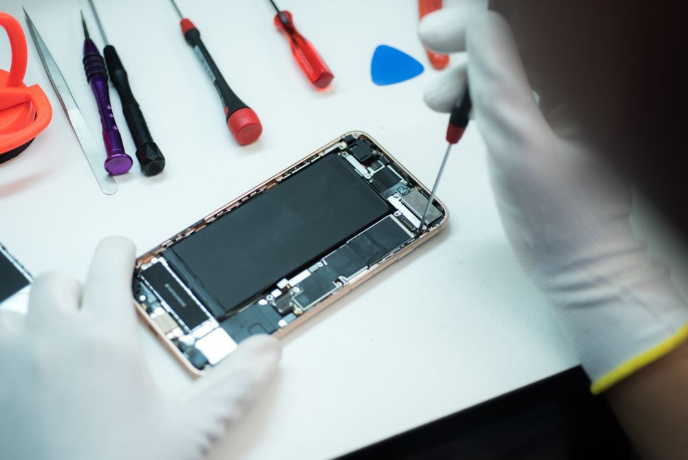Technician performing phone repair in Alice Springs by replacing internal smartphone components.