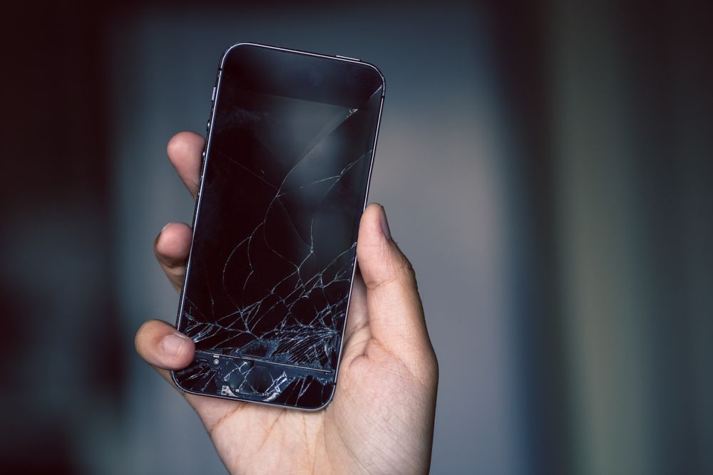 Hand Holding a Smartphone With a Cracked Screen — Phone Hut in Alice Springs, NT