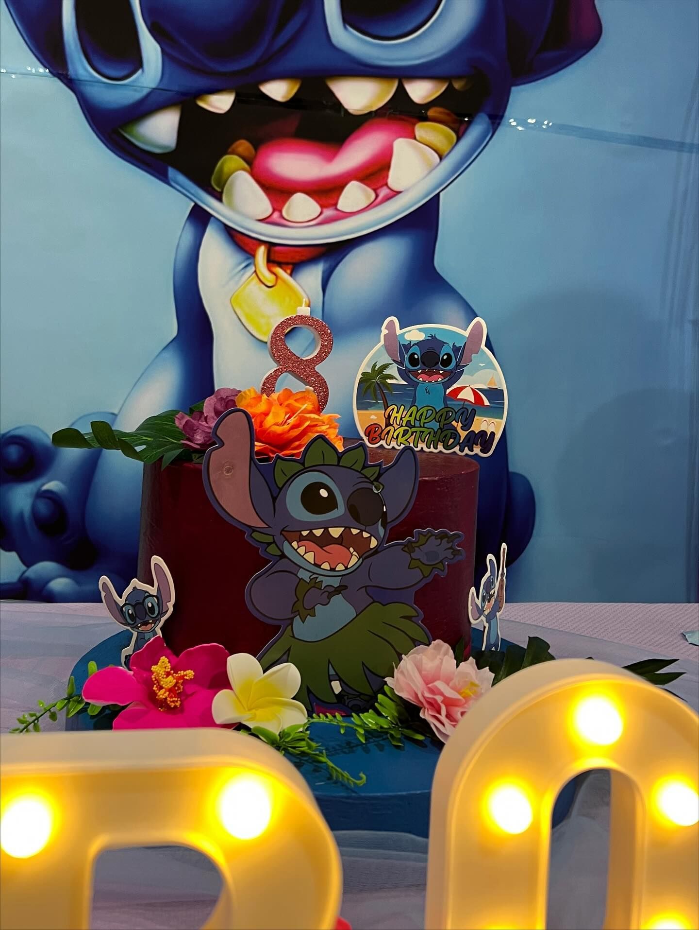 Torta di compleanno a tema Stitch con decorazioni a tema cartone animato, fiori e lettere