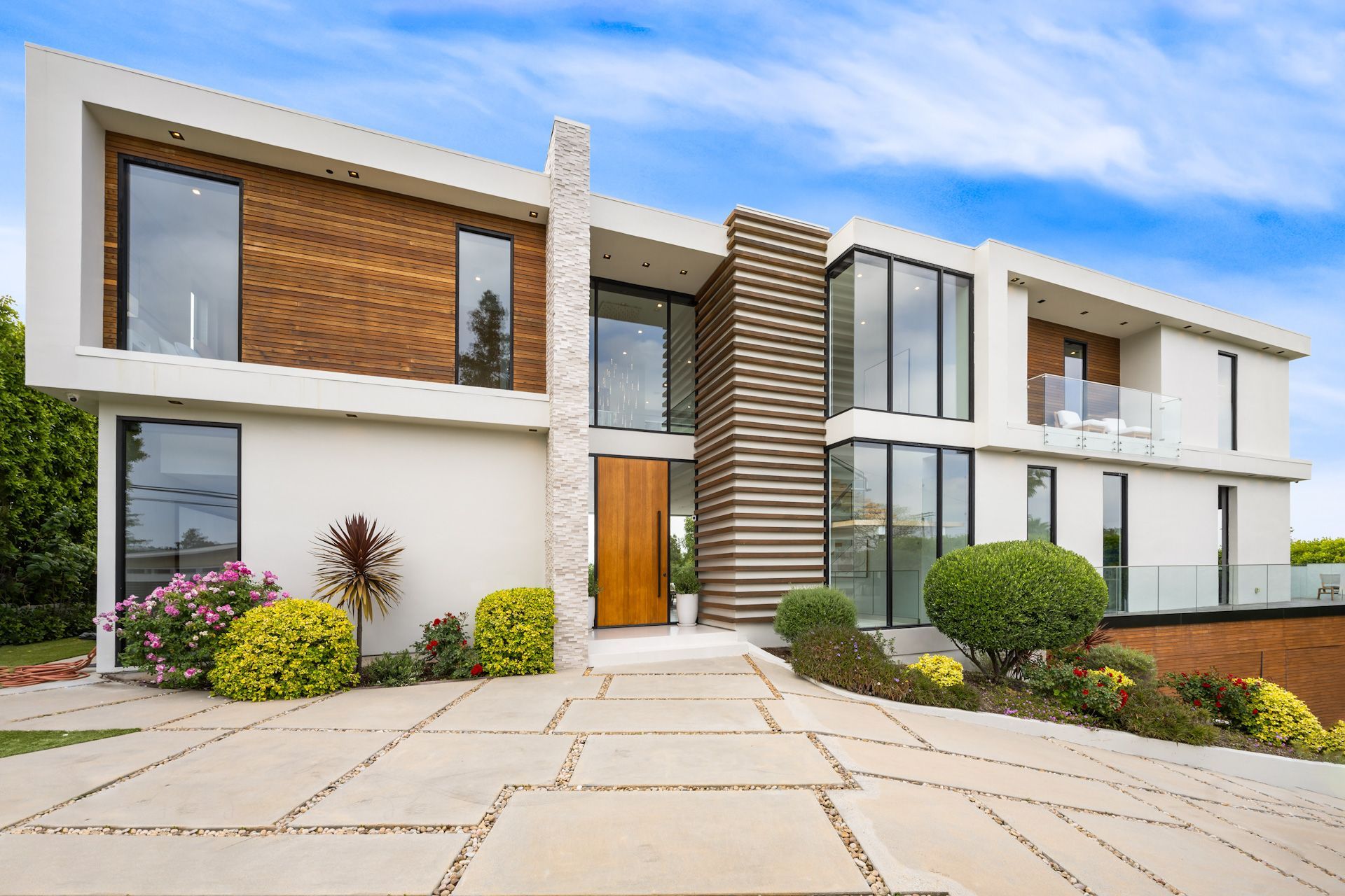 A large modern house with a lot of windows and a wooden door.