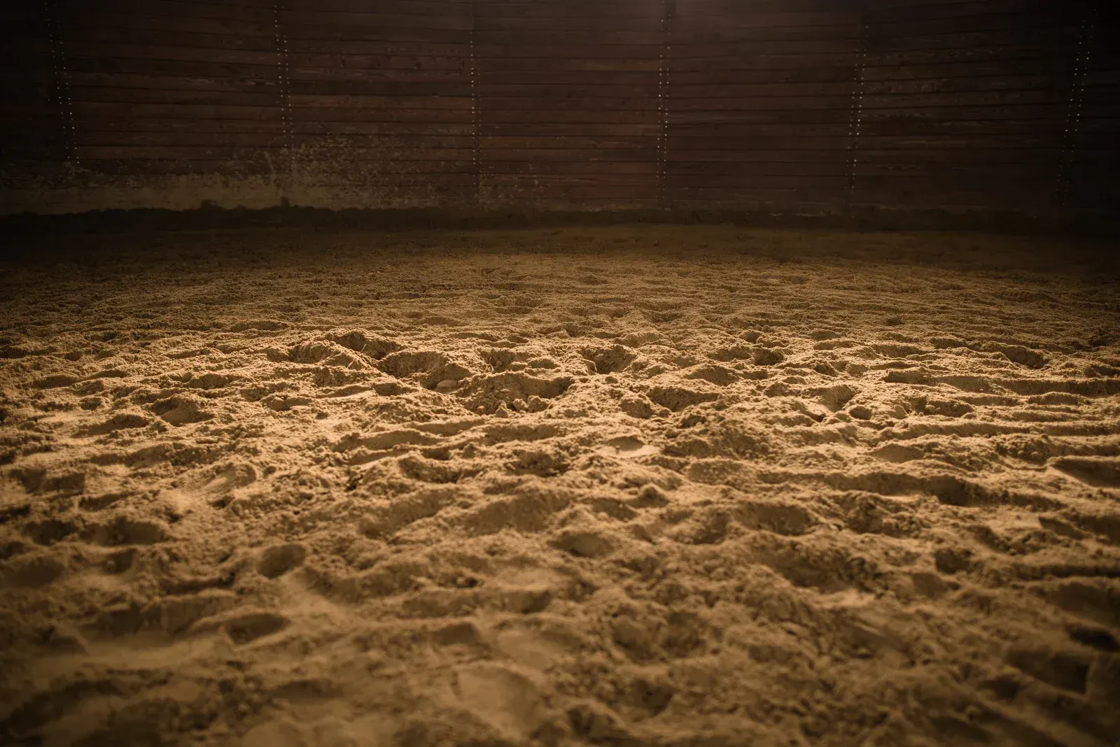 There are many footprints in the sand in the dark.