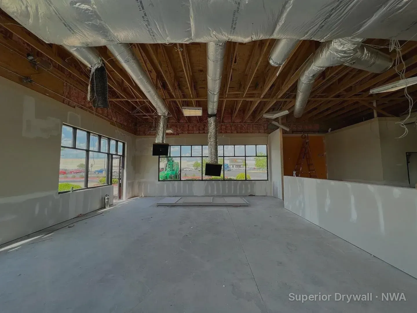 Commercial drywall installation inside a new Zaxby's restaurant build in Arkansas, with hung and taped walls under open ceiling ductwork