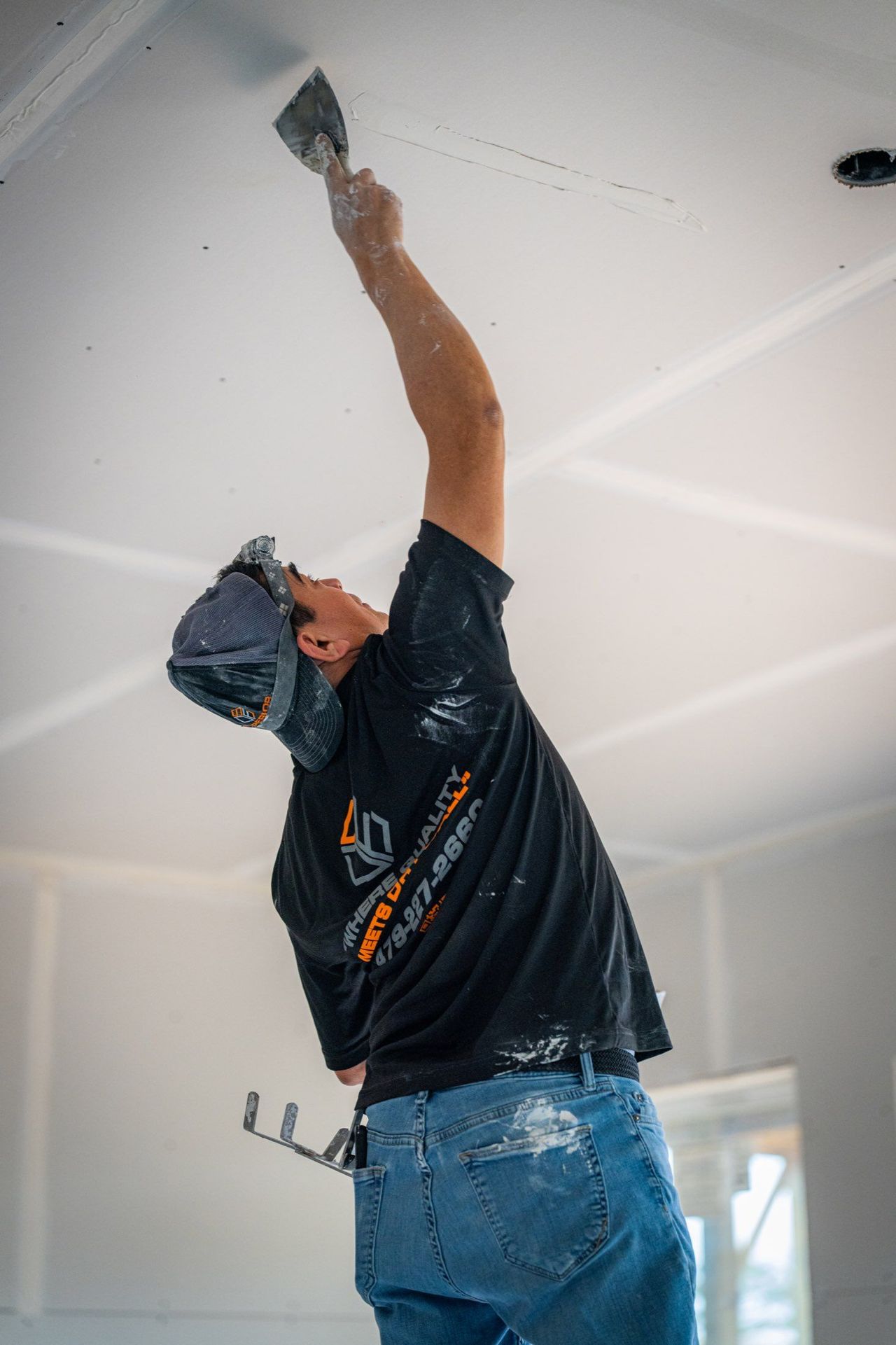 Superior Drywall & Finishing crew member taping and finishing ceiling drywall seams in Northwest Arkansas