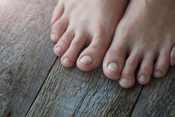 Bare feet on a weathered wooden floor, close-up of toes and planks