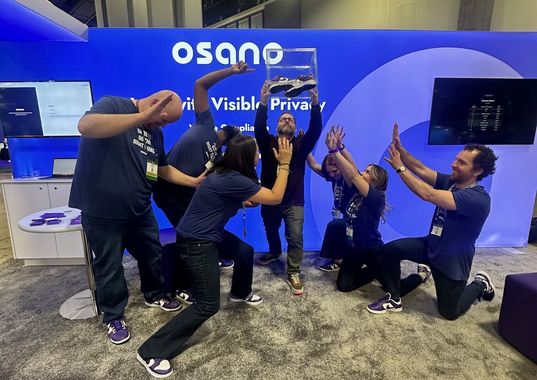 Team celebrating a giveaway win at the Osano conference booth