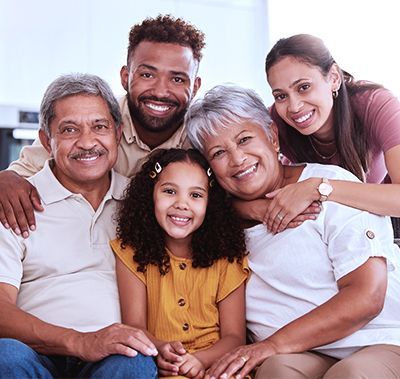 Smiling family gathered on a couch, hugging closely in a bright living room
