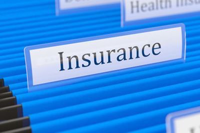 Blue file folder labeled “Insurance” among other folders in a filing system