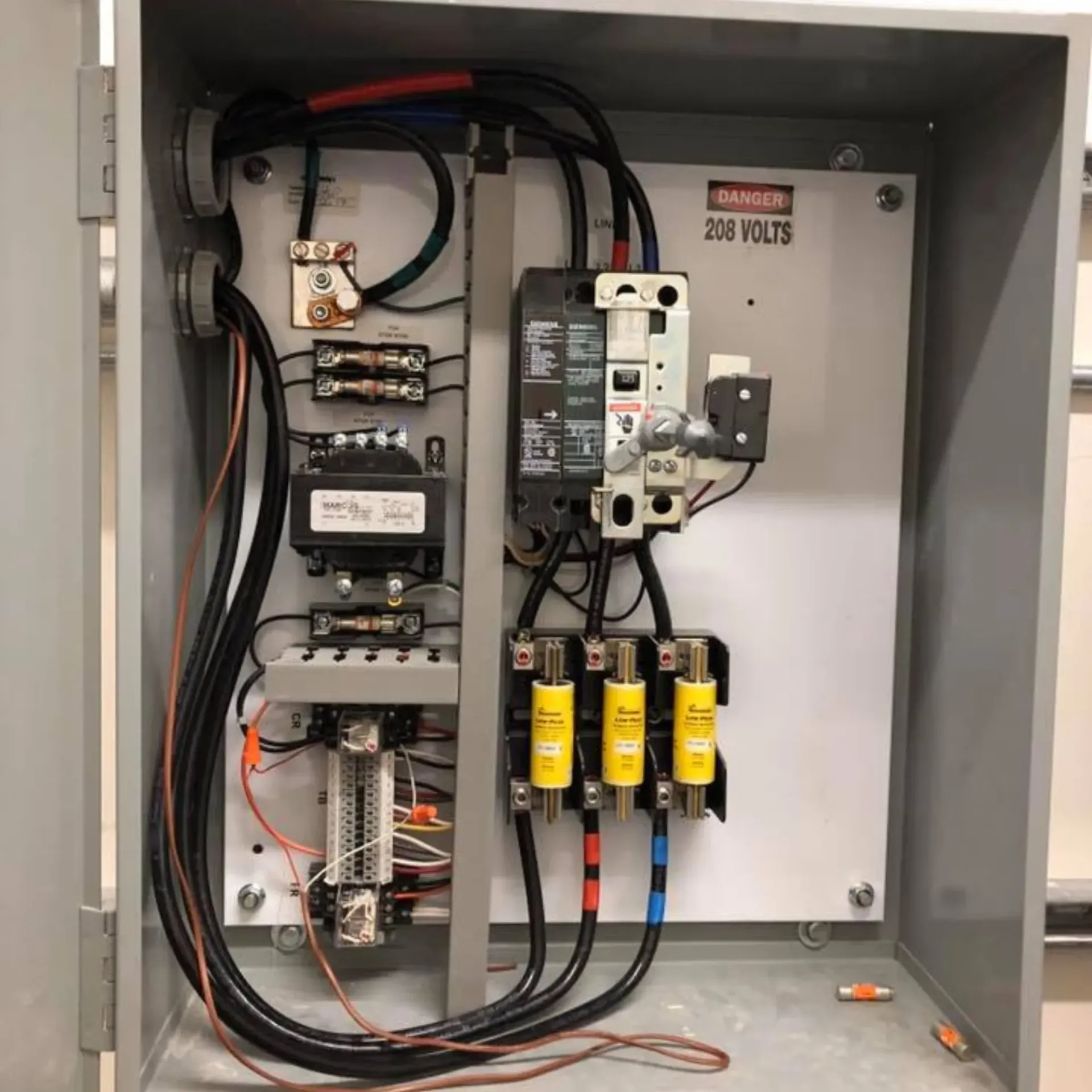 Sanchez Electric and Remodeling - The inside of a electrical box with 220 volts written on it