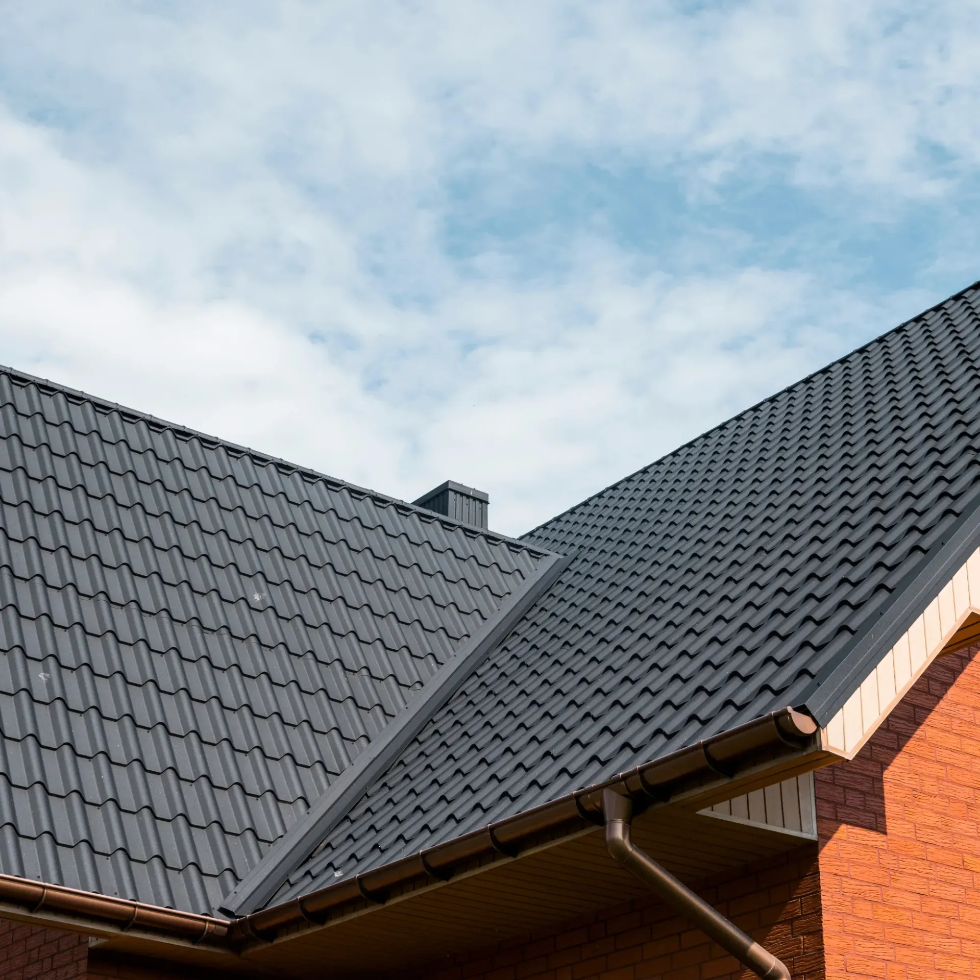 Sanchez Electric and Remodeling - A brick house with a black roof and gutters