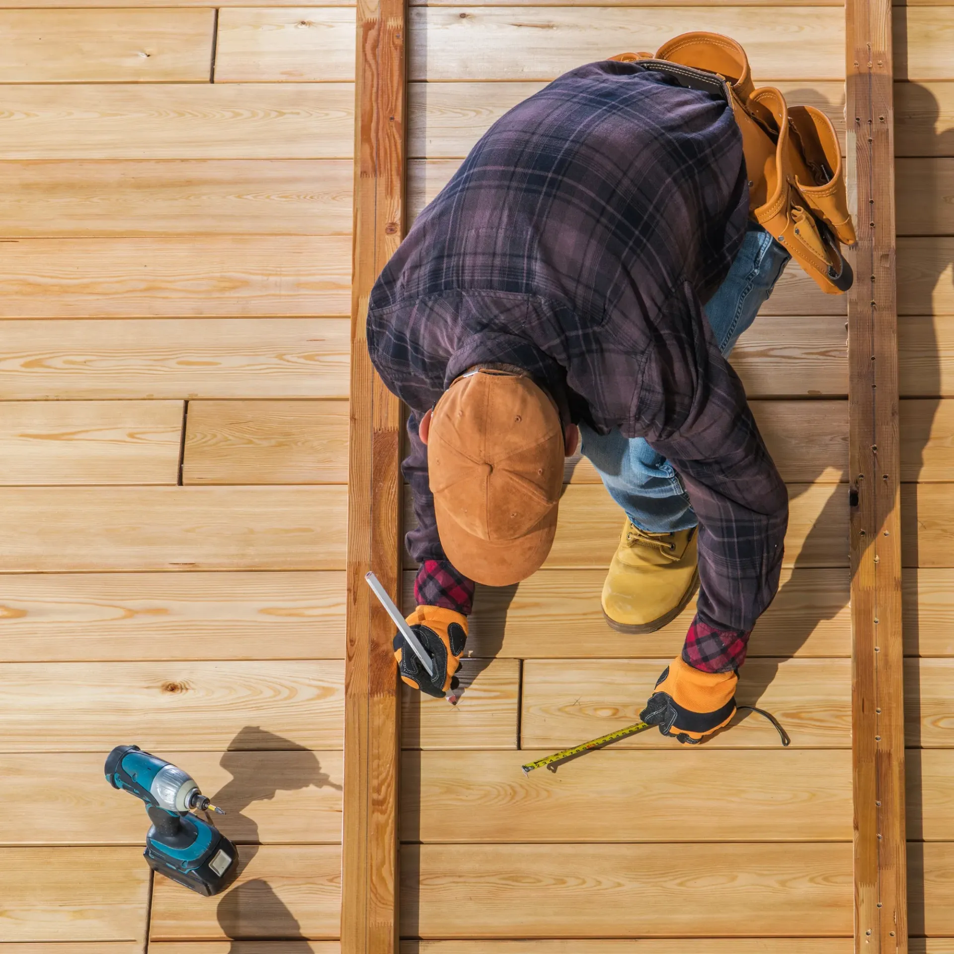 Sanchez Electric and Remodeling - A man is measuring a piece of wood with a tape measure.