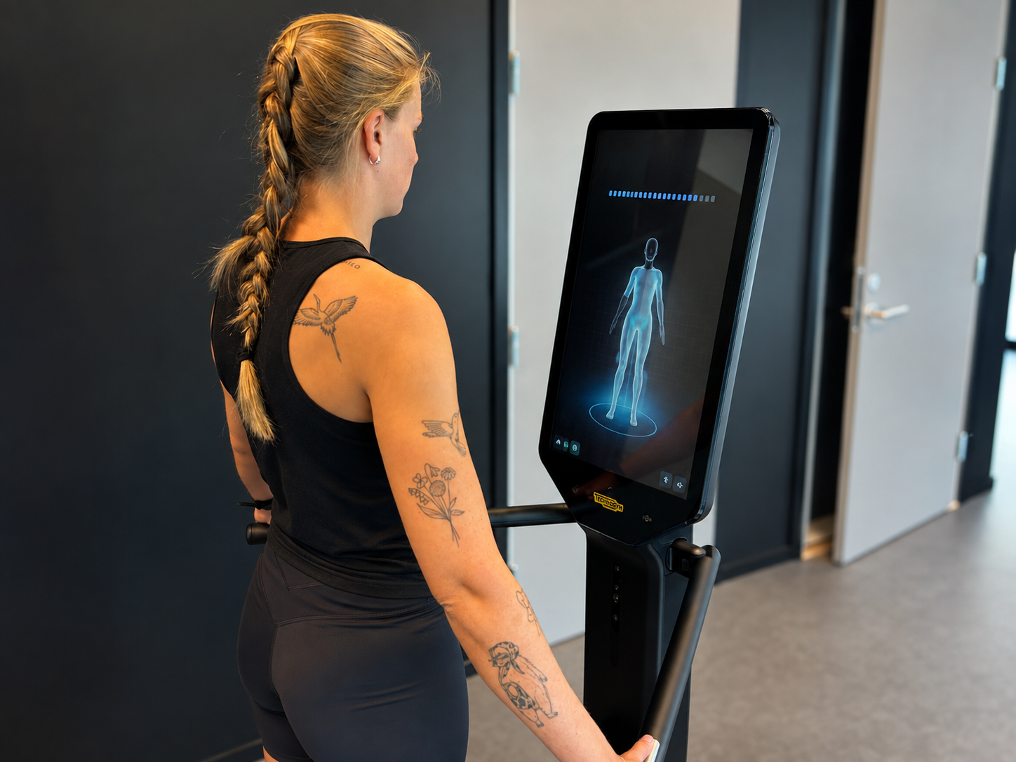 Medlem bruker et digitalt Technogym-apparat hos Trim Her