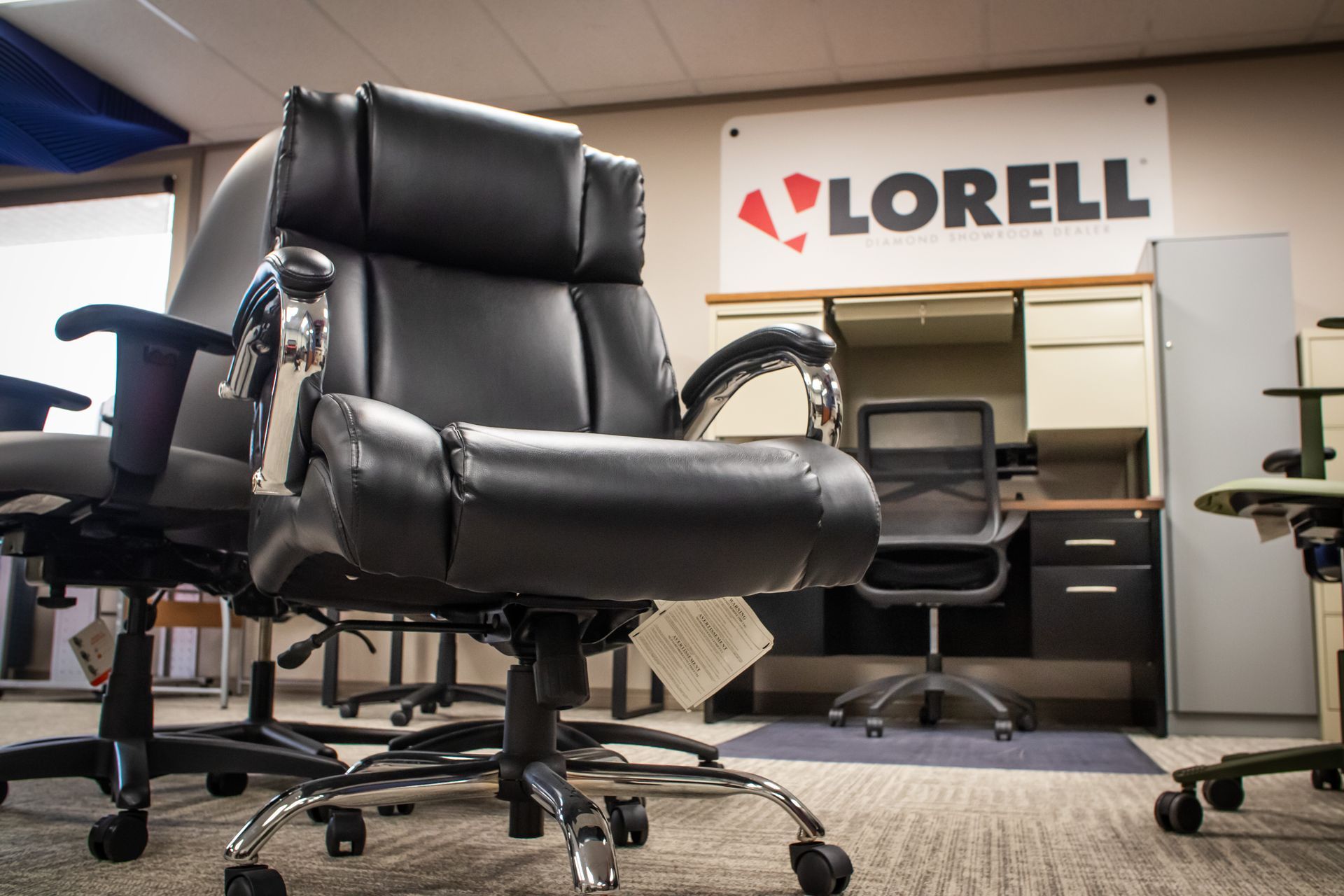 A black office chair is sitting in front of a lorell sign.