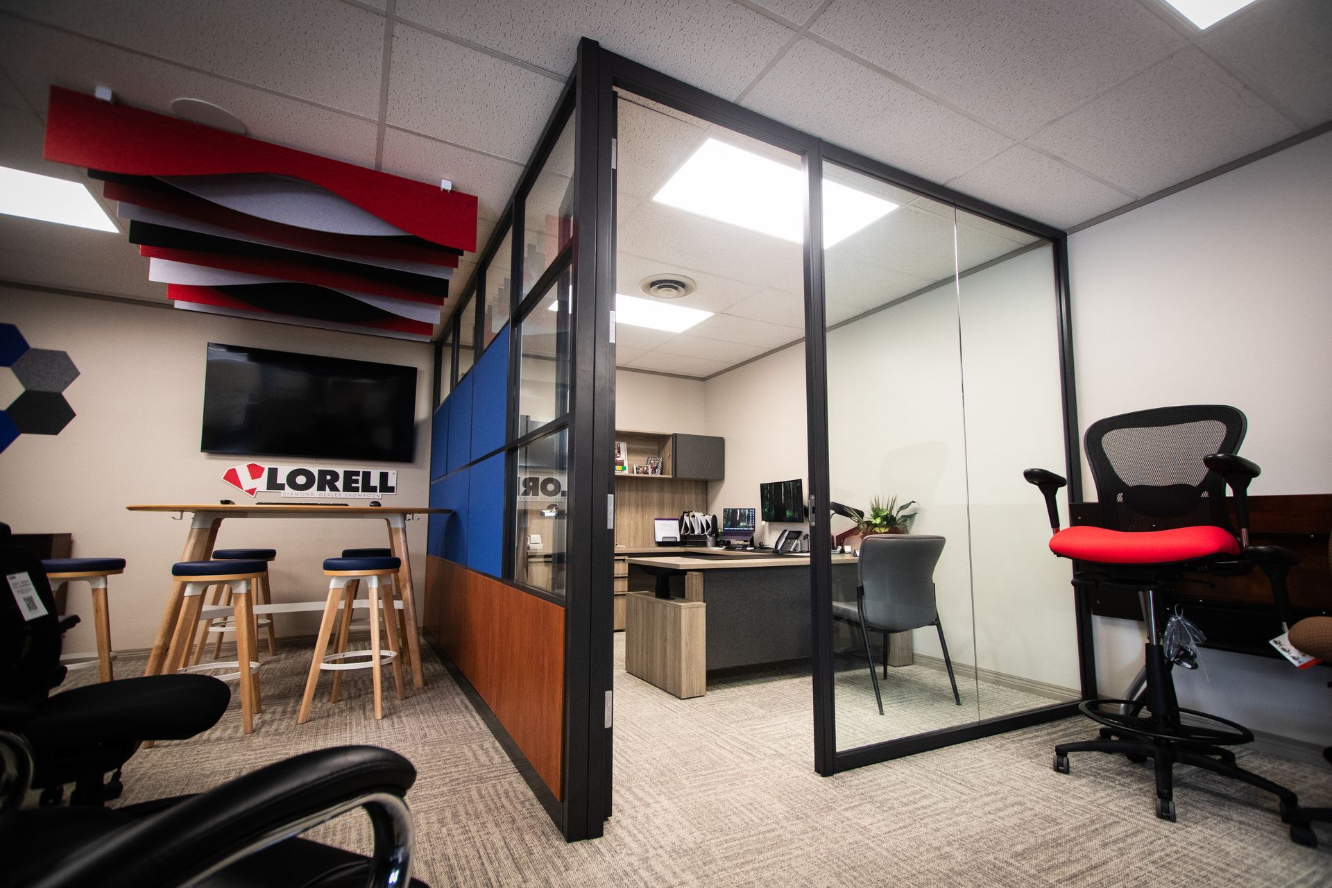 A room with a desk and chairs and a sign that says lorell on the wall.