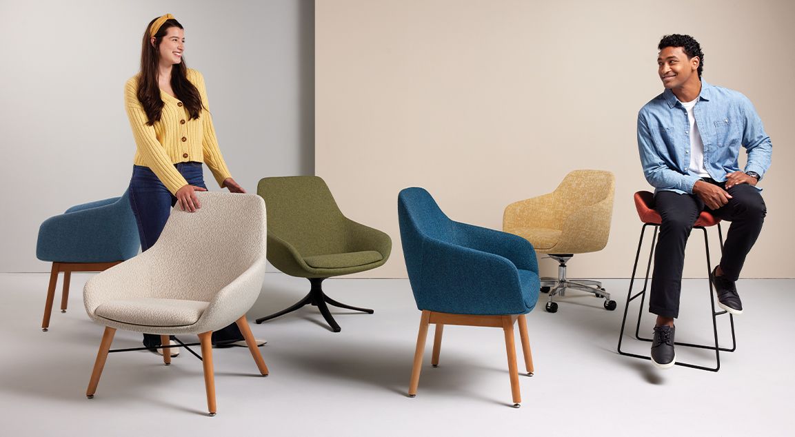 A man and a woman are standing next to a group of chairs.
