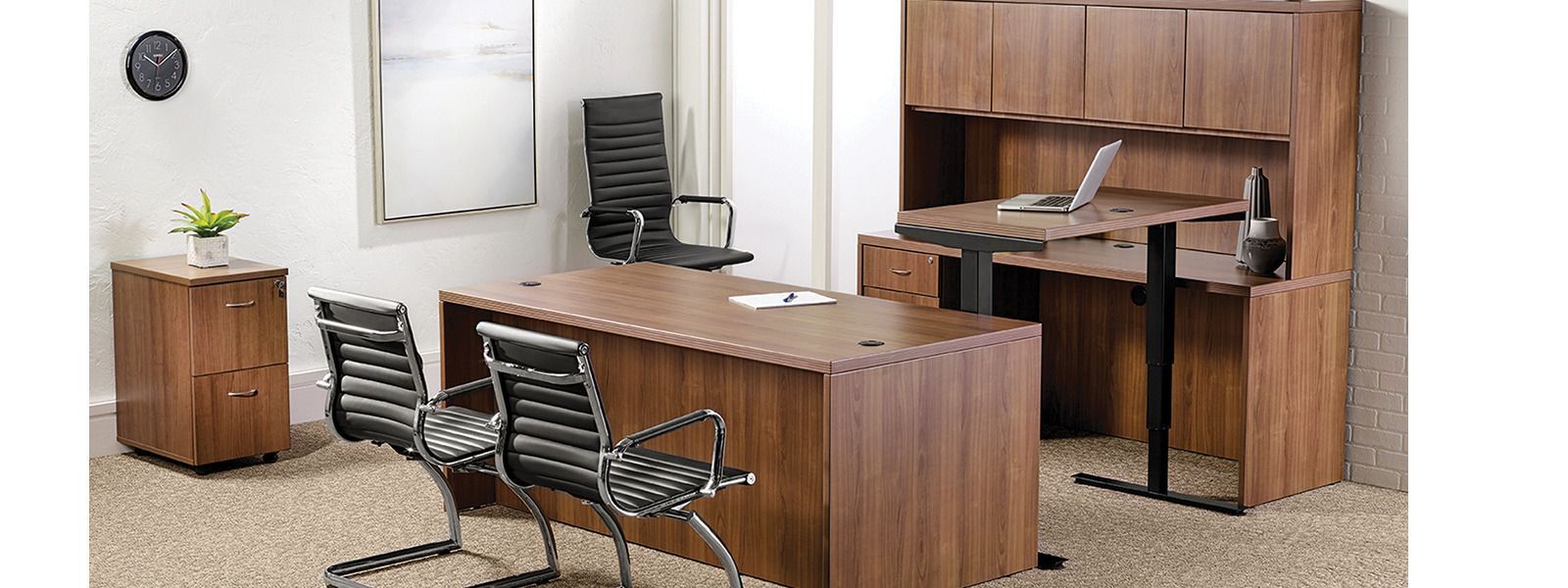 A room with a desk and chairs and a clock on the wall.
