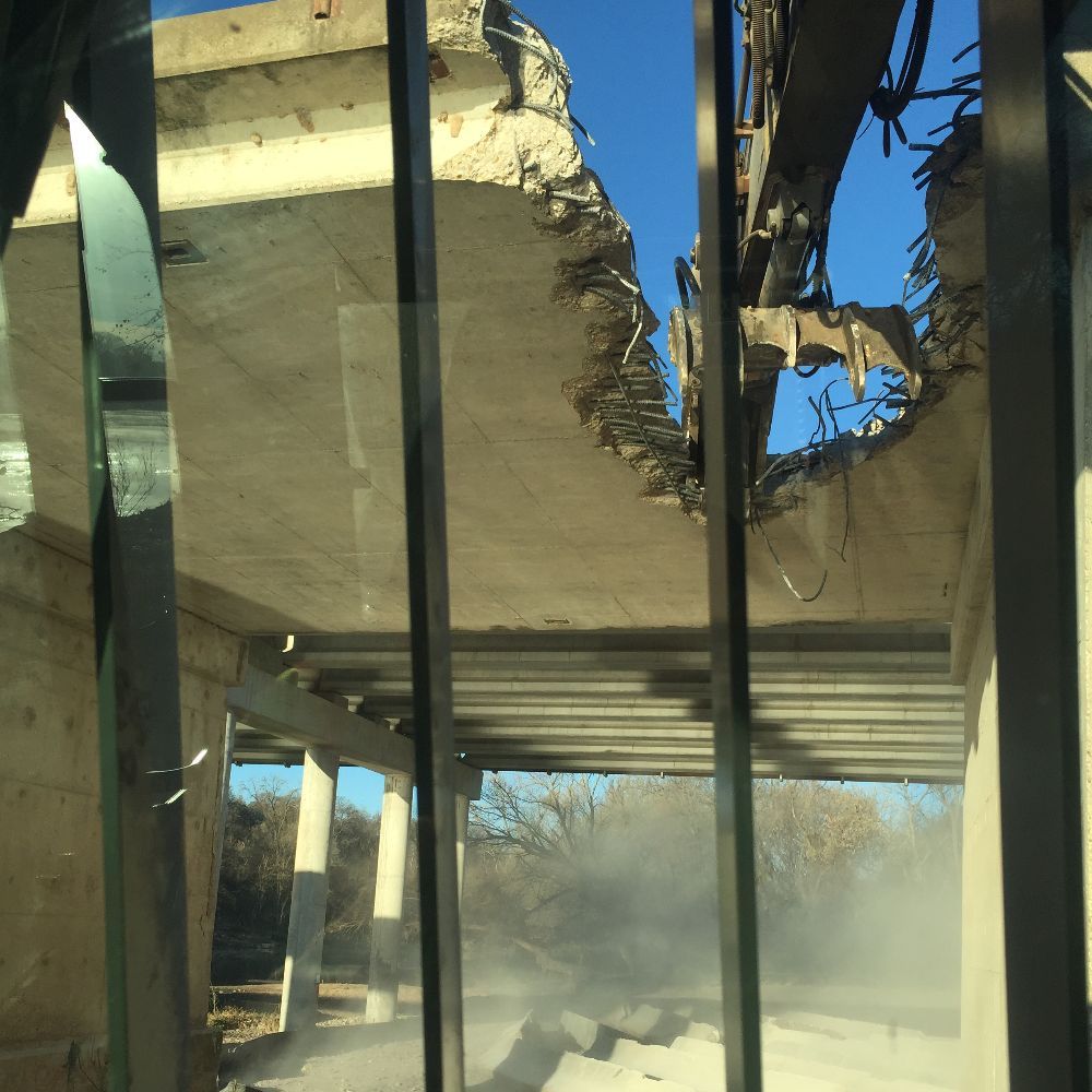 Collapsed concrete structure with broken beams and dust inside a damaged building.