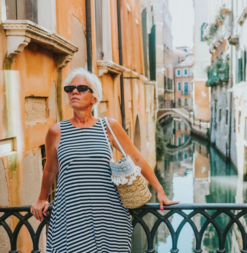 A woman enjoying a solo travel moment at an outdoor café in Europe