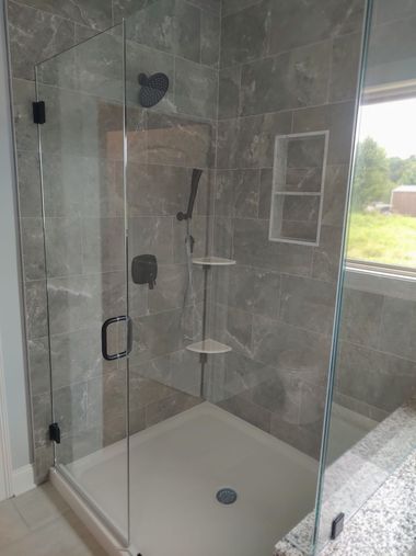 Bathroom vanity with a gray cabinet, white countertop, black fixtures, and a large mirror.