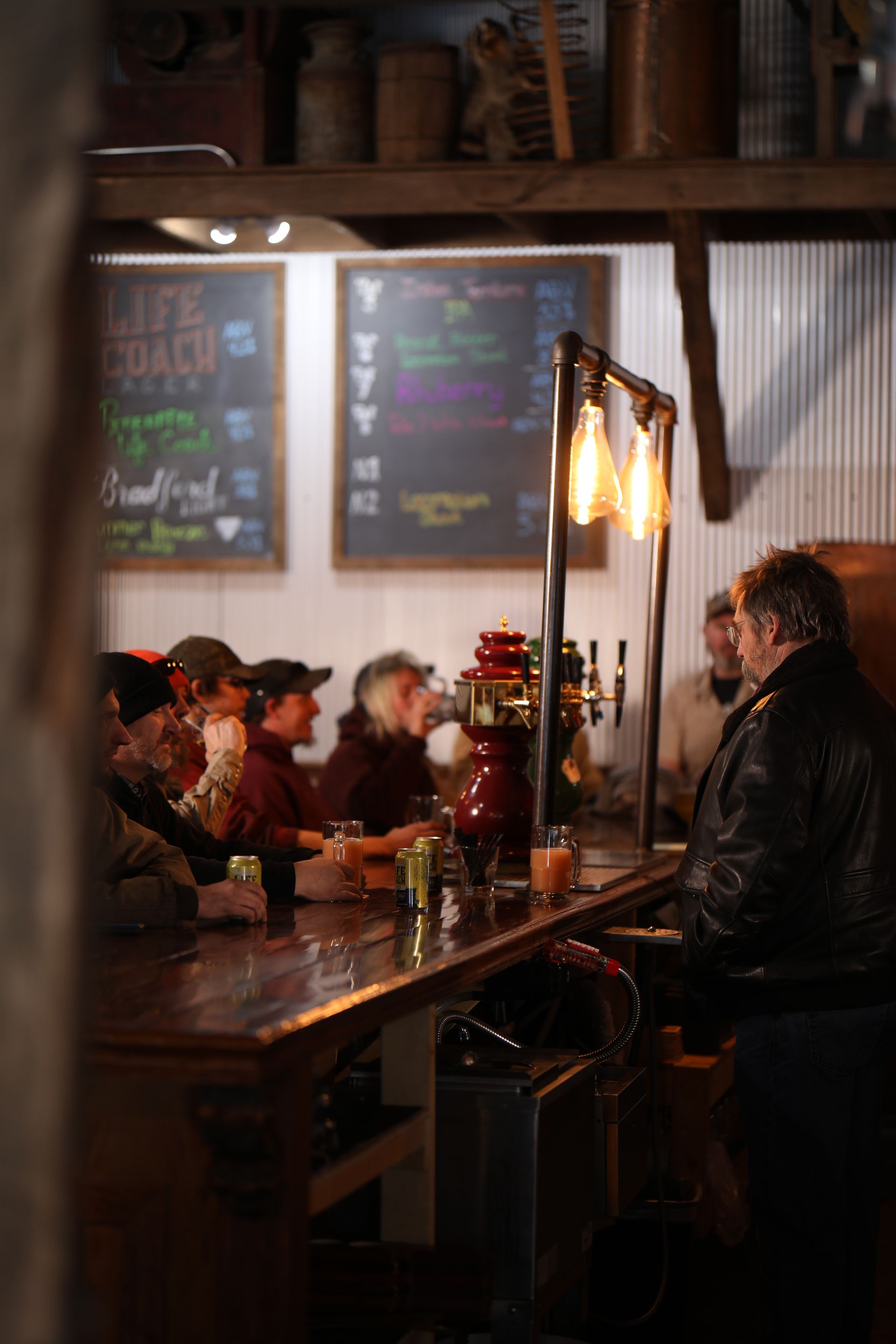 People enjoying cans of Life Coach with Pineapple barside at The Brewery