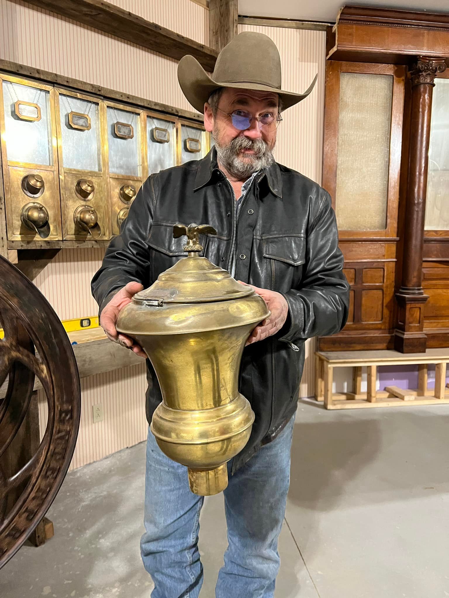 KTB Co president Brad holds a brass cannister from an antique coffee mill