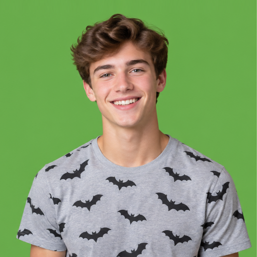 Smiling person in a gray bat-print T-shirt against a green background
