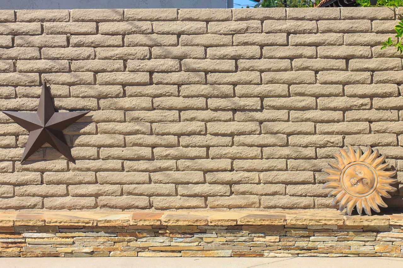 Brick wall with a metal star and sun decoration.