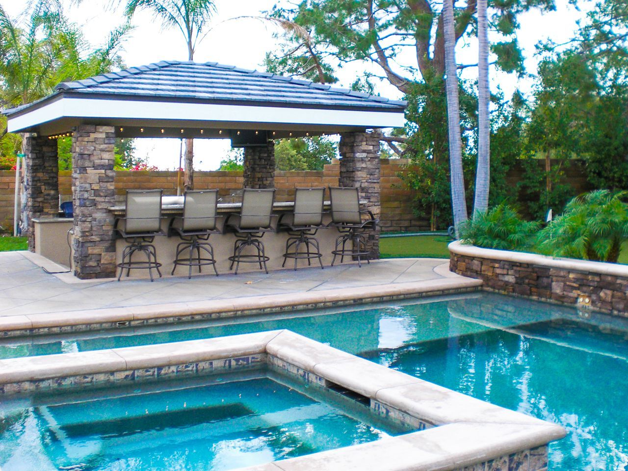 Swimming pool with an outdoor bar and seating area.
