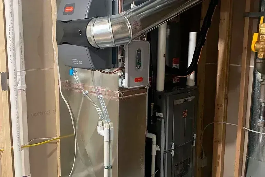 HVAC system installed in a residential setting. Furnace and humidifier visible with ductwork and wiring.