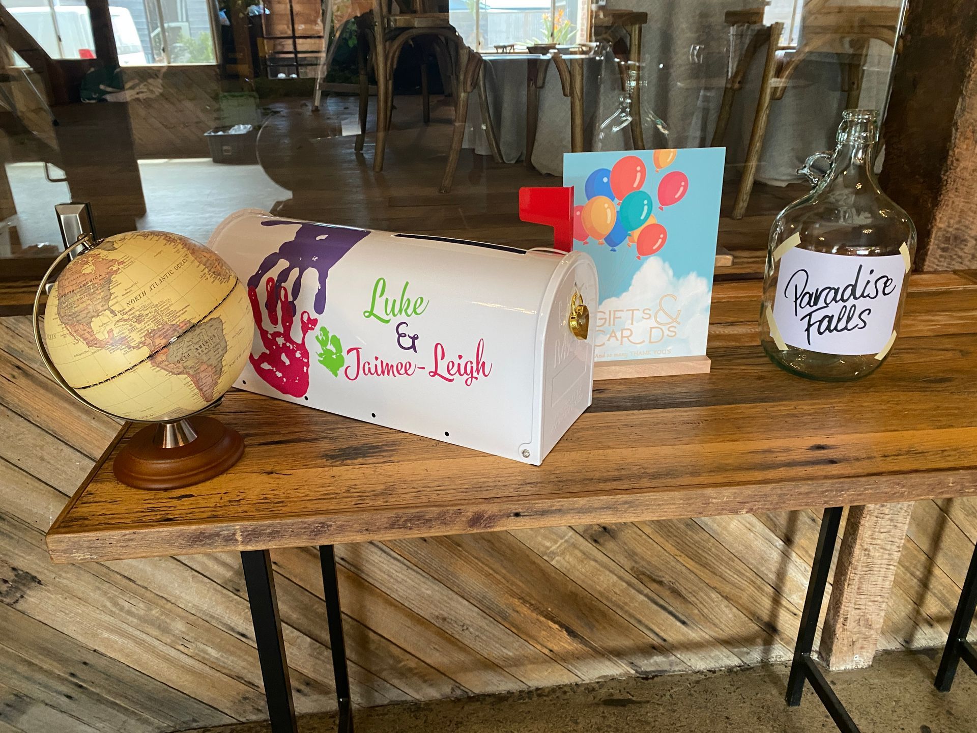 A wooden table with a mailbox and a globe on it.