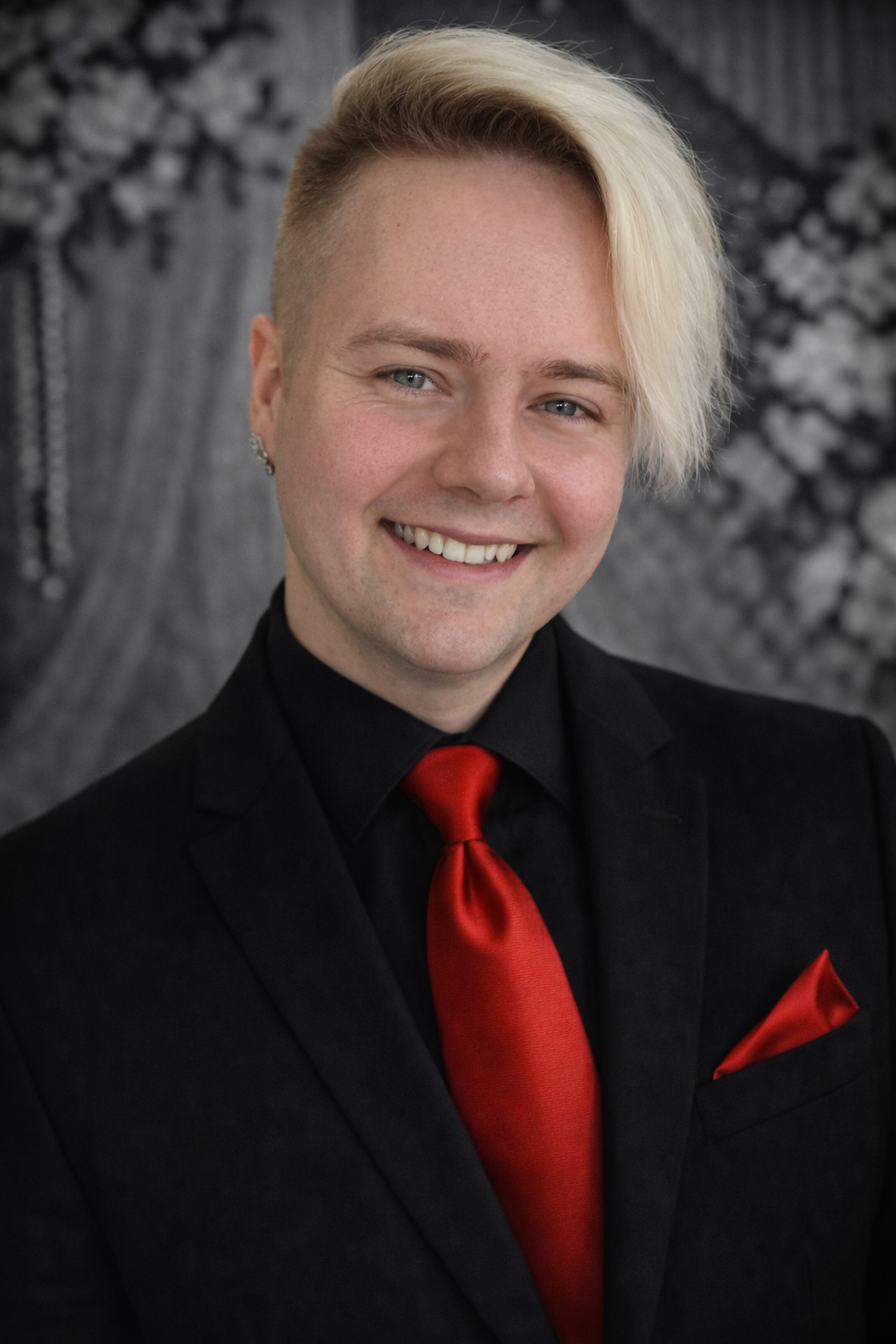 A man in a suit and tie is smiling for the camera.
