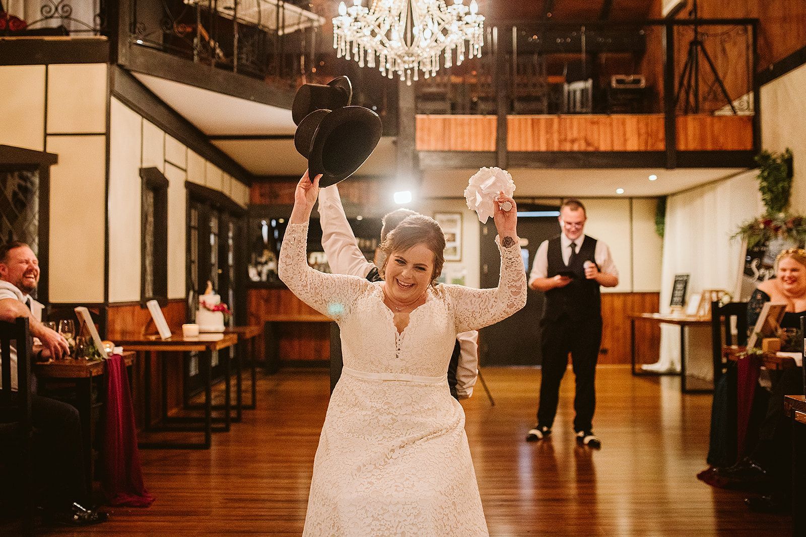 A bride in a wedding dress is throwing her bouquet in the air.