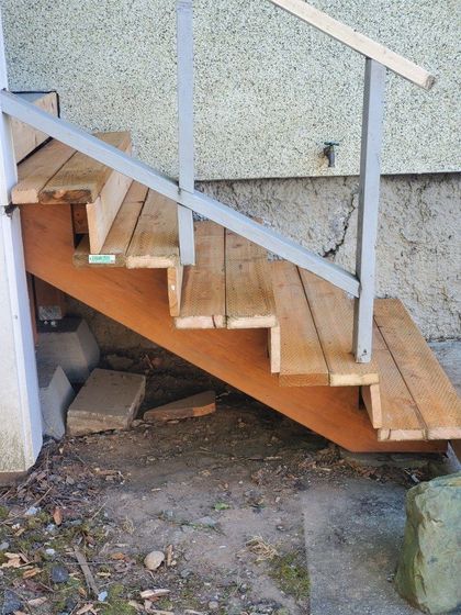 a set of wooden stairs with a metal railing