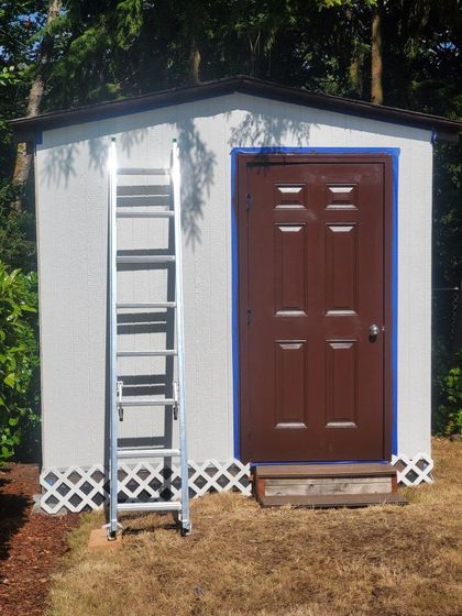 a white shed with a brown door
