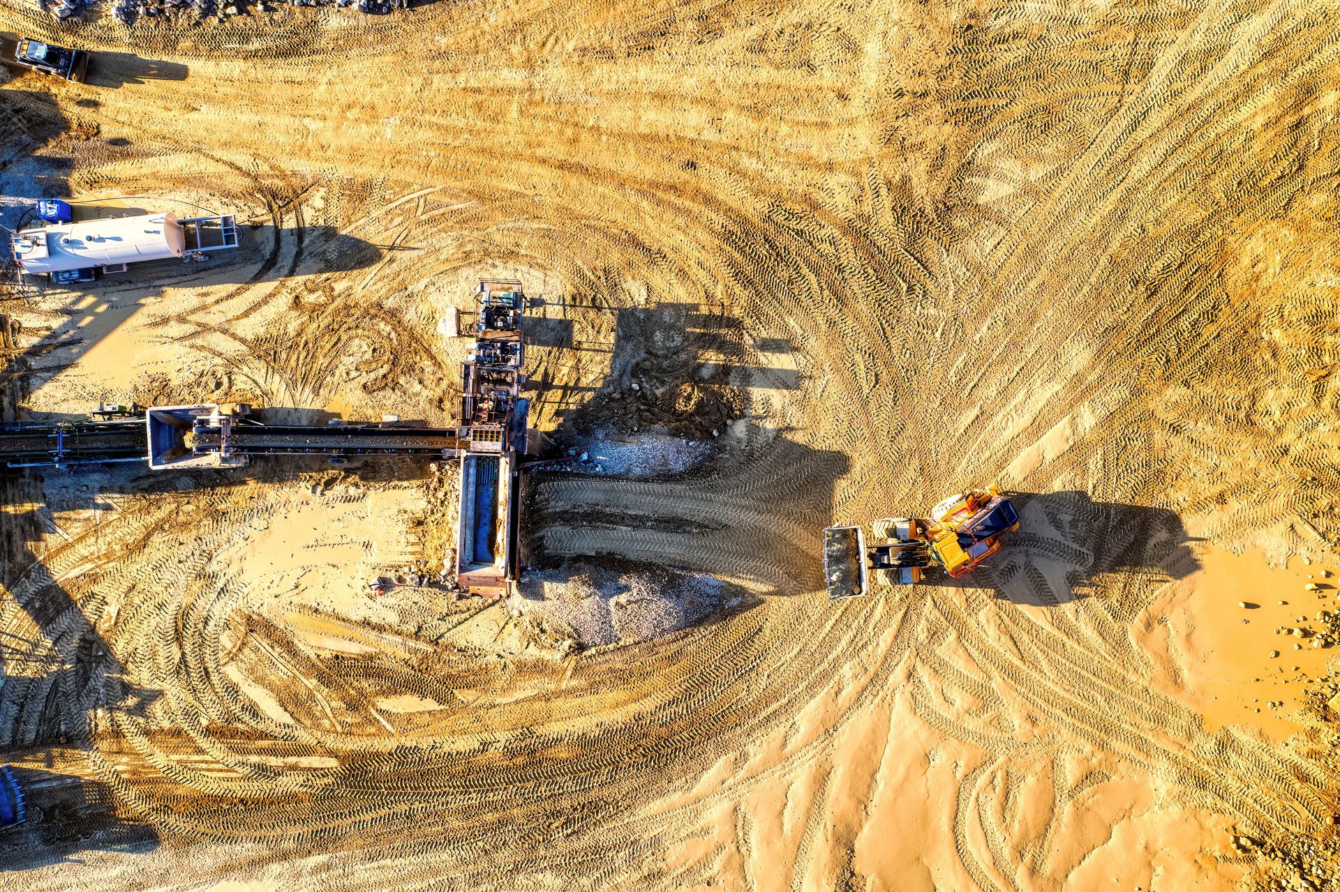 Aerial view of construction machinery working on a sandy excavation site