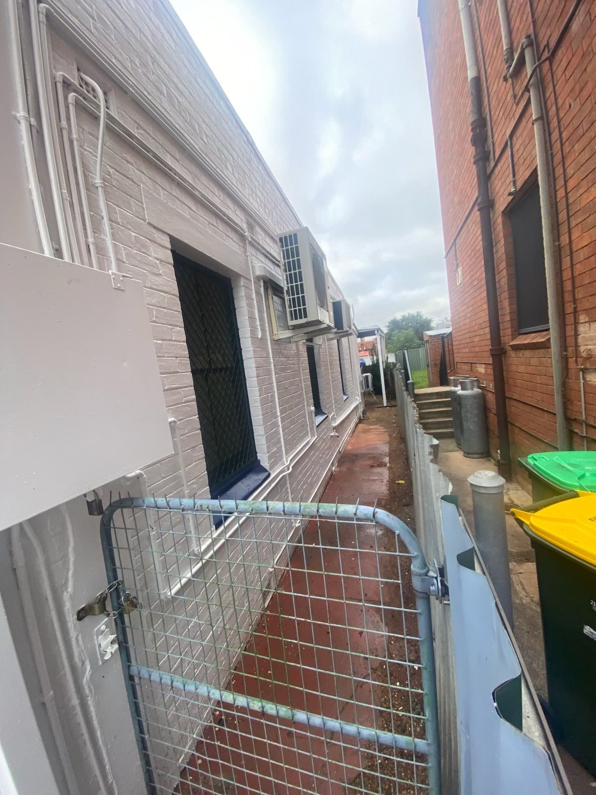 A Narrow Outdoor Alley Between a White Brick Building and a Brick Wall — Robert Seeliger Painter & Decorator in Dubbo, NSW