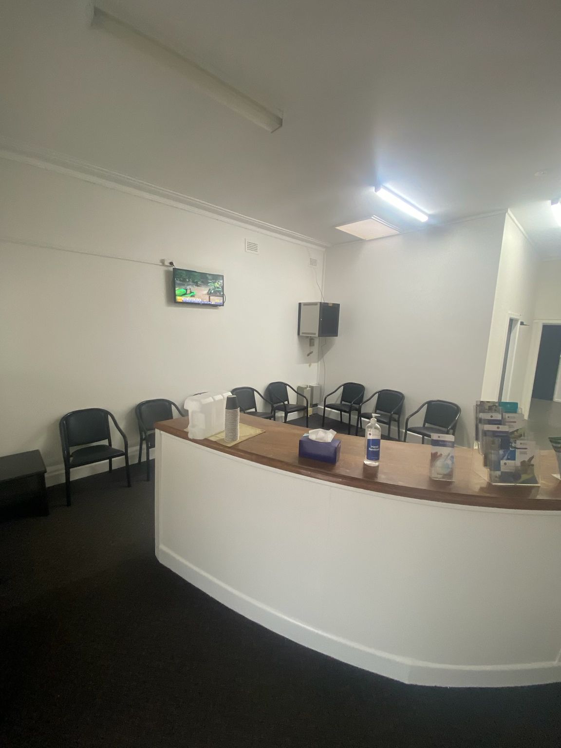 Reception Area With Curved White Desk and Wall-mounted TV — Robert Seeliger Painter And Decorator in Nyngan, NSW