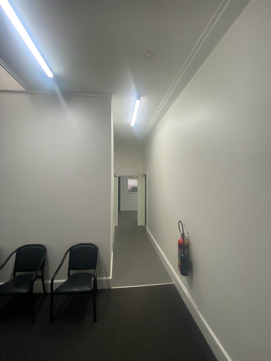Narrow White Hallway With Black Chairs, Ceiling Light — Robert Seeliger Painter And Decorator in Nyngan, NSW