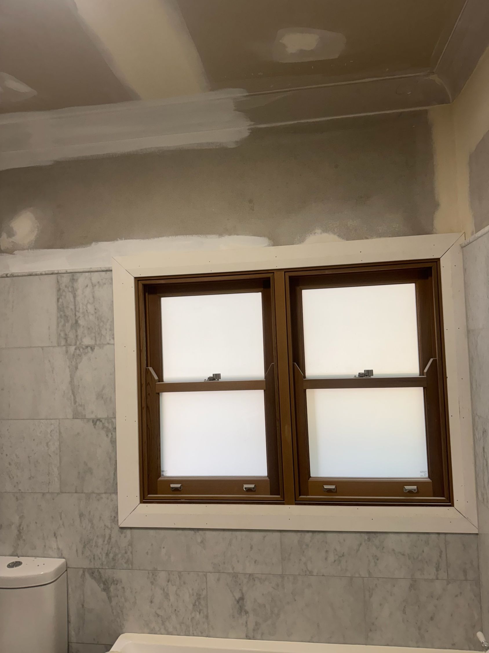 A Bathroom Wall With Grey Stone Tile, Unfinished Drywall — Robert Seeliger Painter & Decorator in Dubbo, NSW