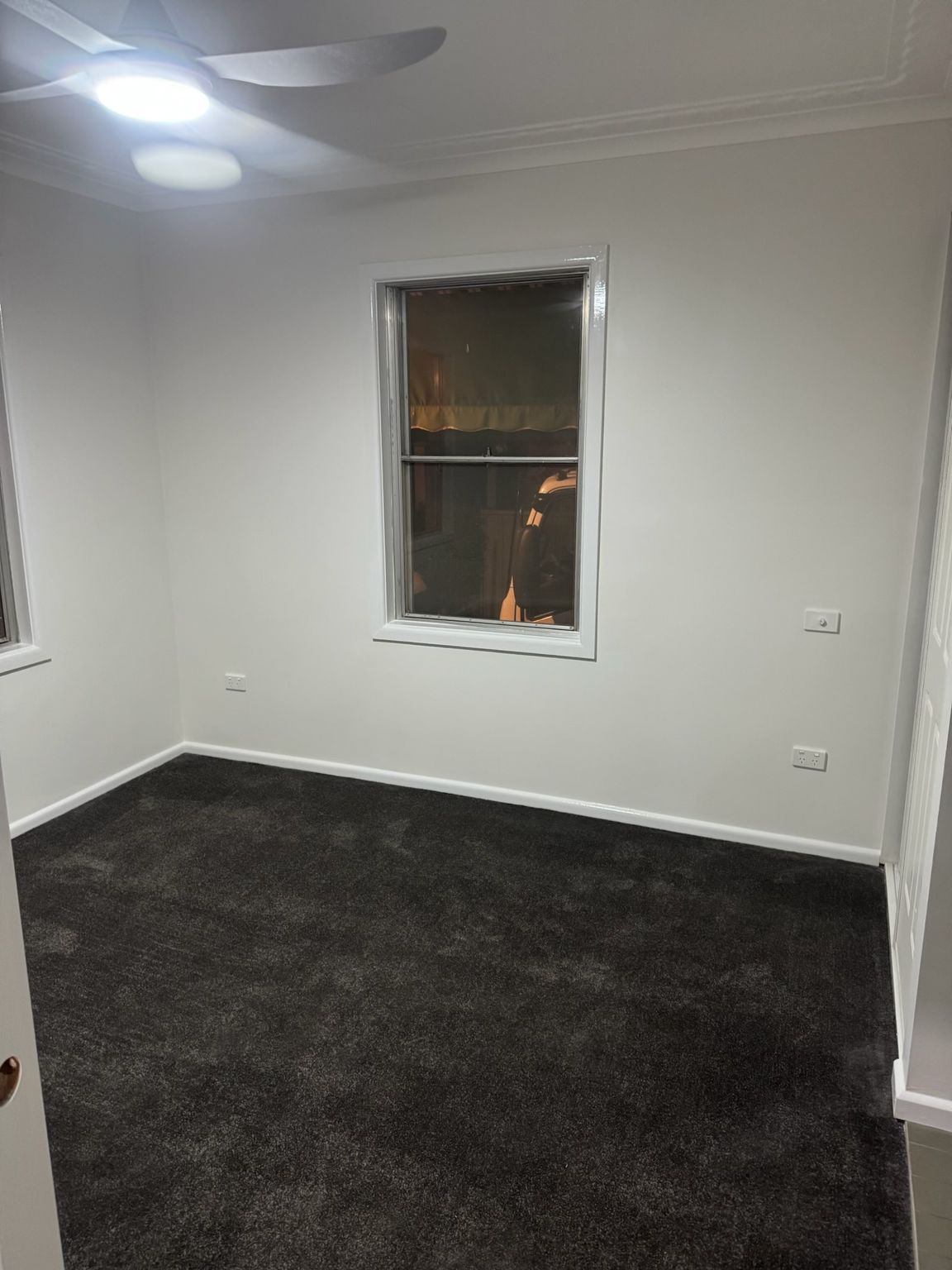 Empty White Room With Dark Carpet, Two Windows, and a Ceiling Fan — Robert Seeliger Painter And Decorator in Parkes, NSW