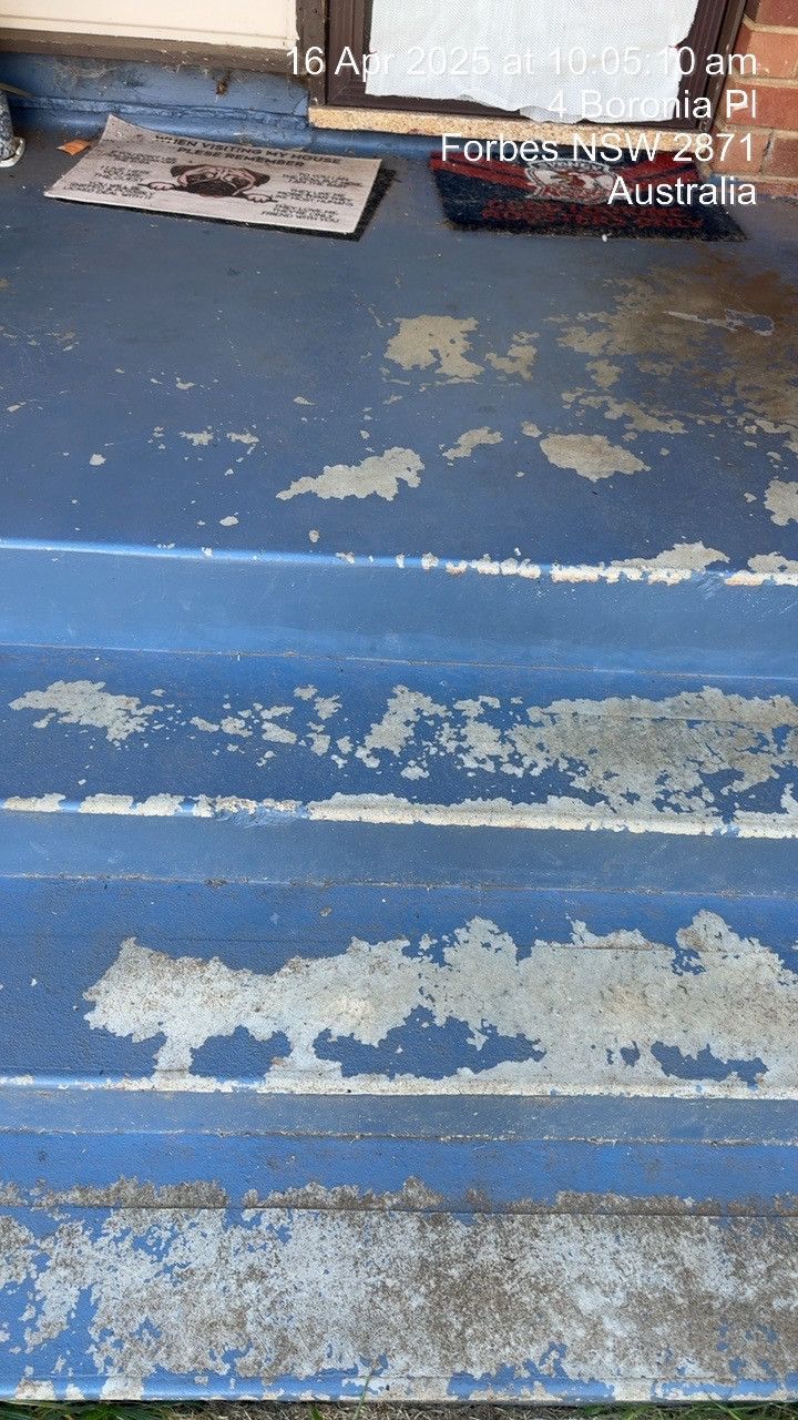 Weathered blue stair steps with peeling paint and worn edges, viewed close up.