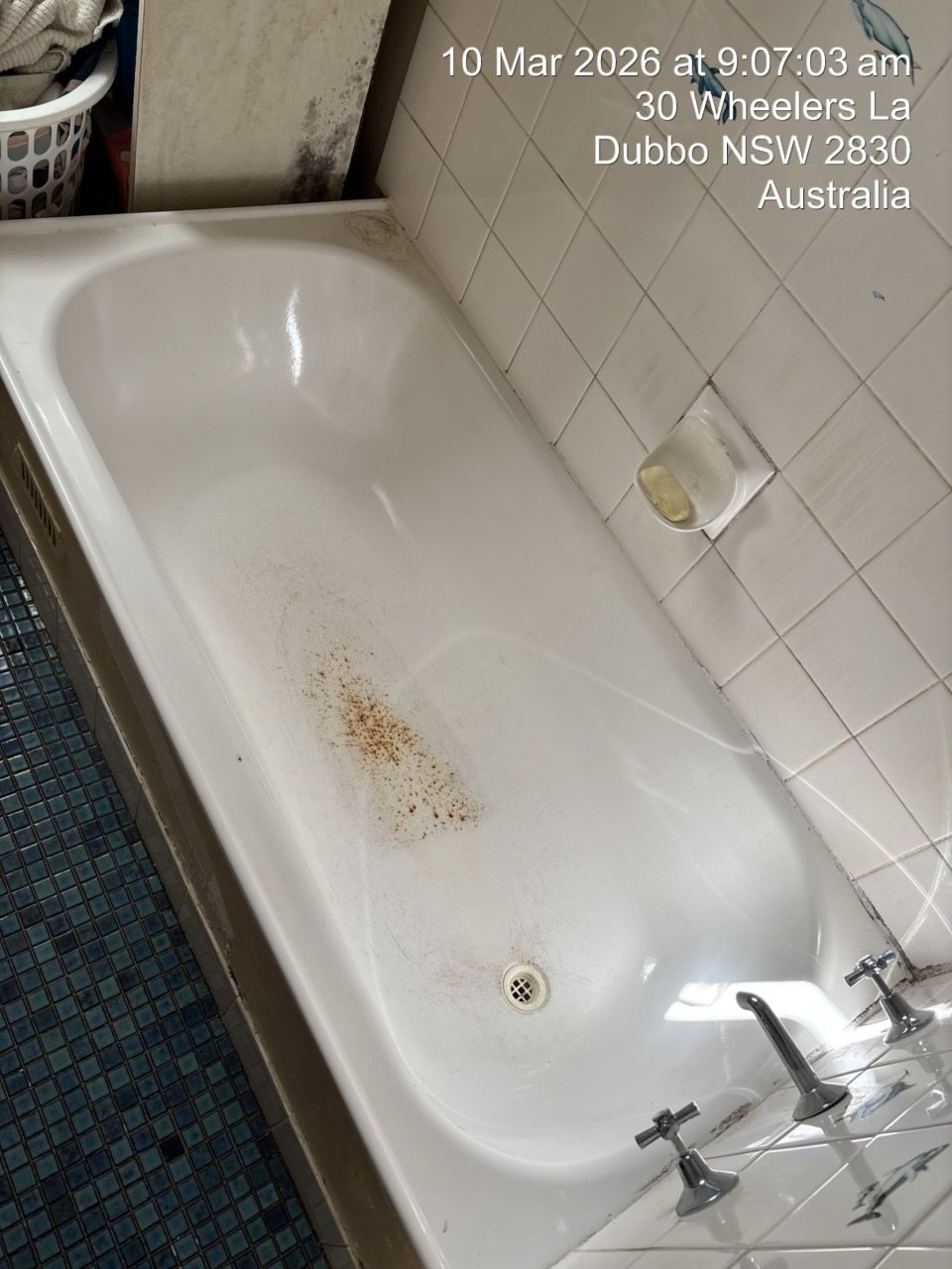 Dirty White Bathtub With Rust Stains and a Faucet in a Tiled Bathroom — Robert Seeliger Painter And Decorator in Dubbo, NSW
