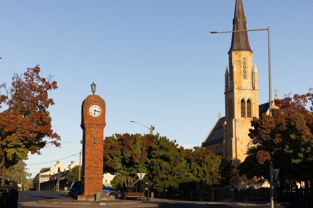 Brick Clock Tower and Tall Church Steeple in a Sunny Town Square — Robert Seeliger Painter & Decorator in Mudgee, NSW