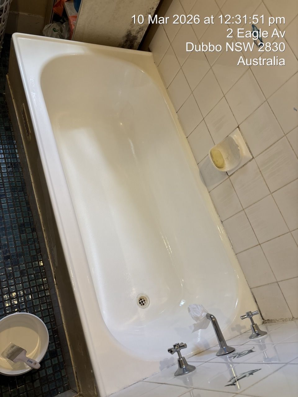 Small Bathroom With a White Bathtub, Tiled Walls, Sink, and a Trash Bin — Robert Seeliger Painter And Decorator in Dubbo, NSW