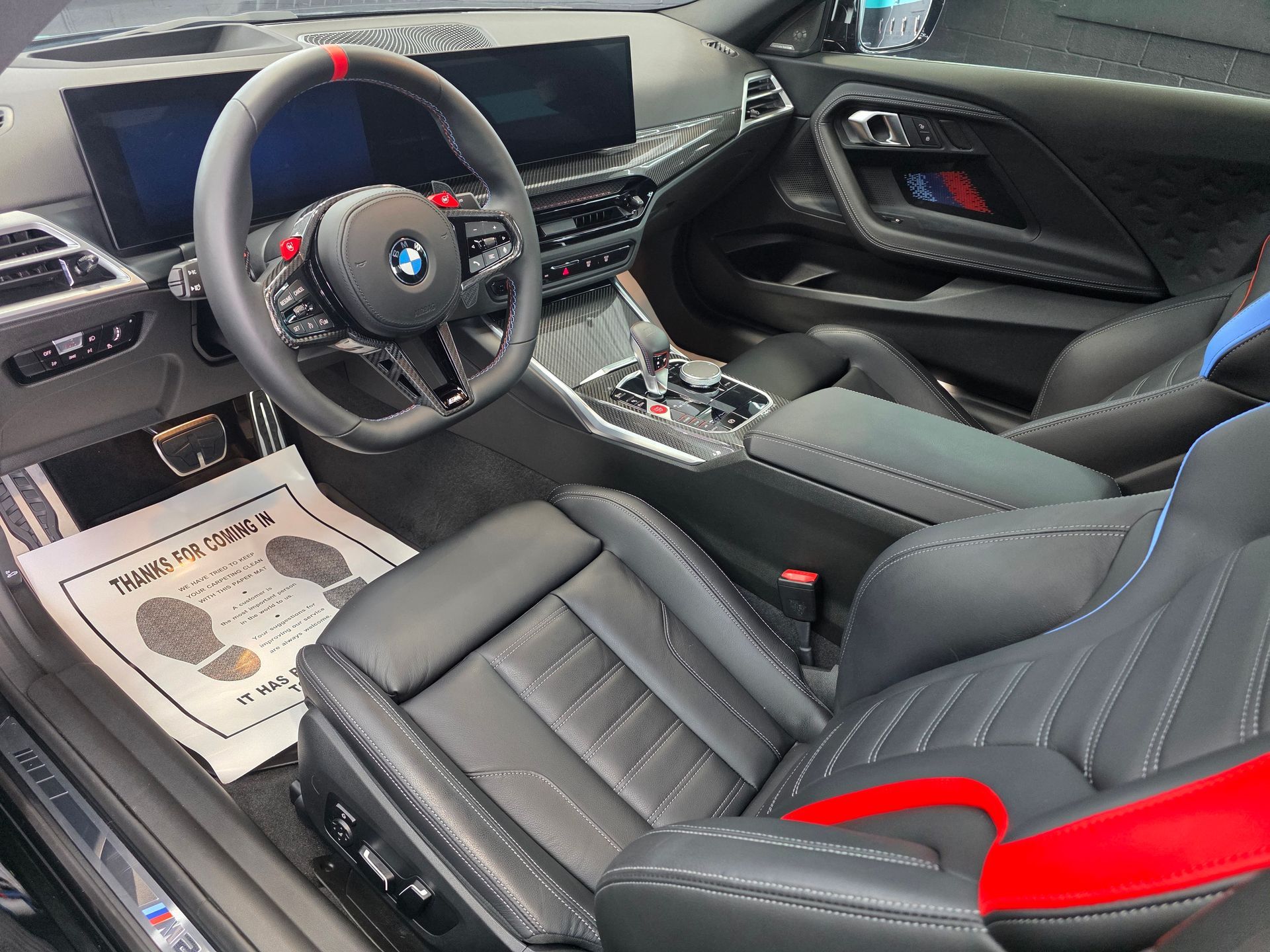 BMW sports car interior with black and red seats, steering wheel, and center console