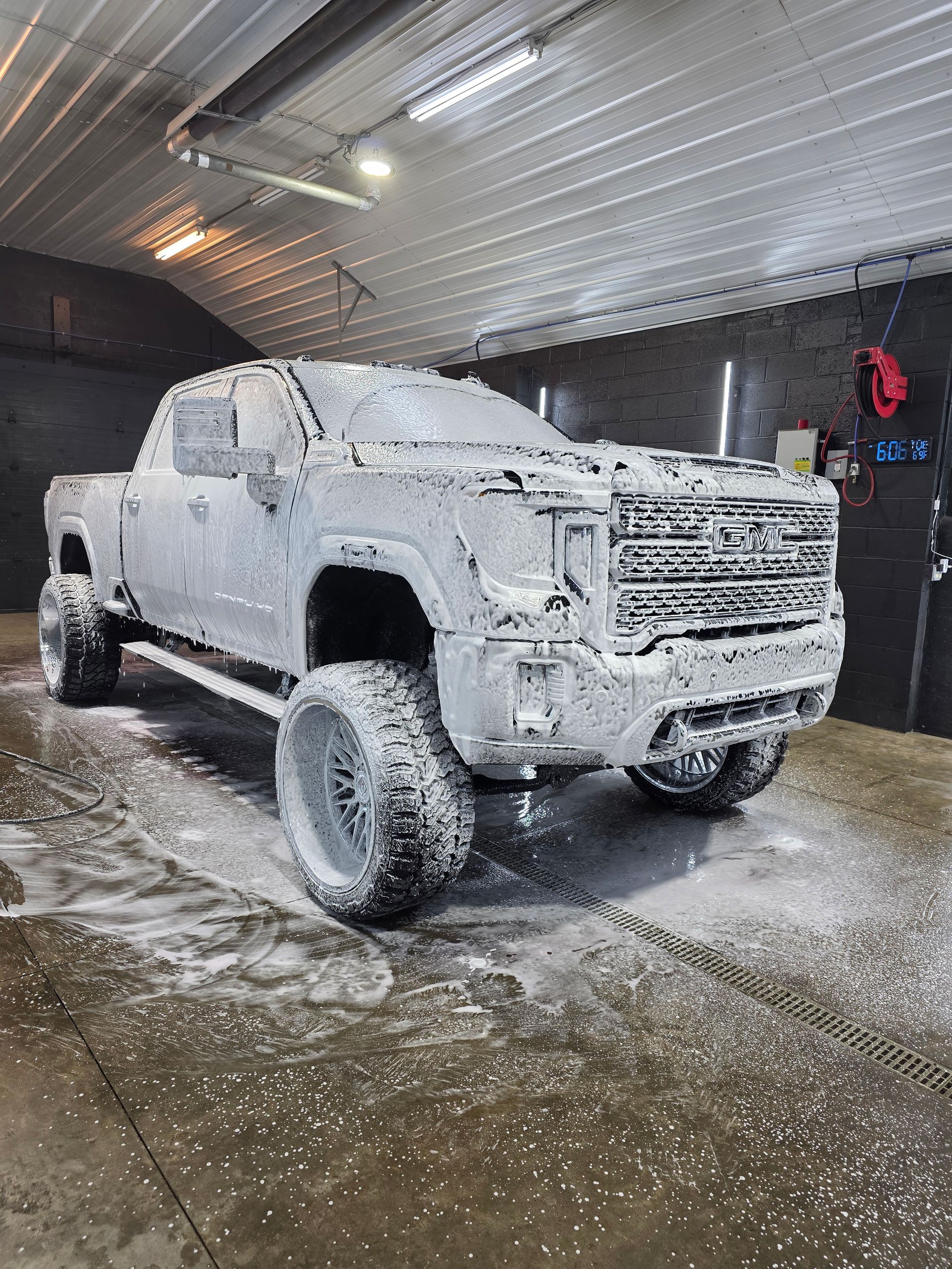 White pickup truck covered in foam during a car wash