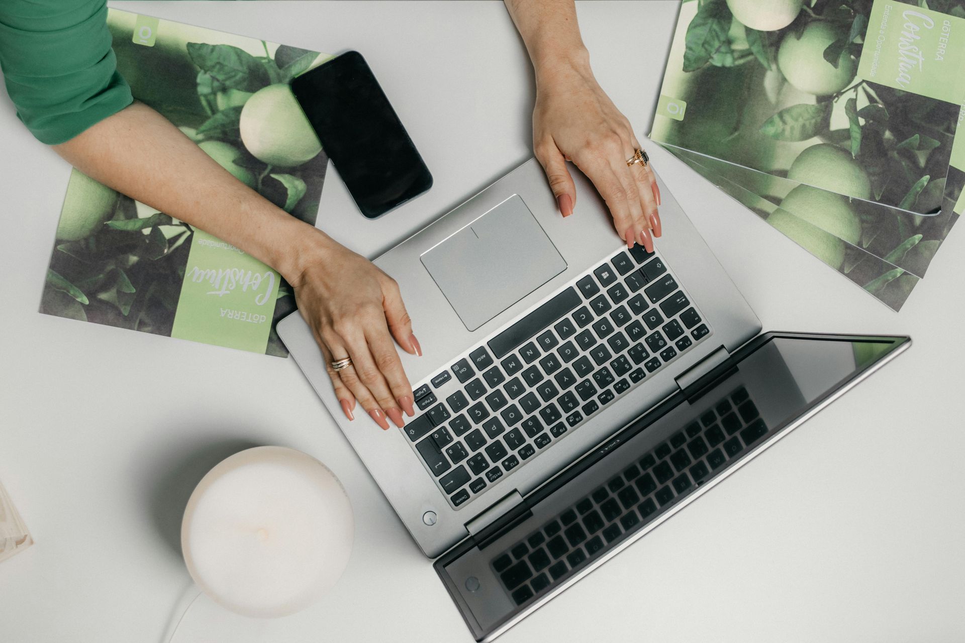 Hands writing content on a laptop keyboard