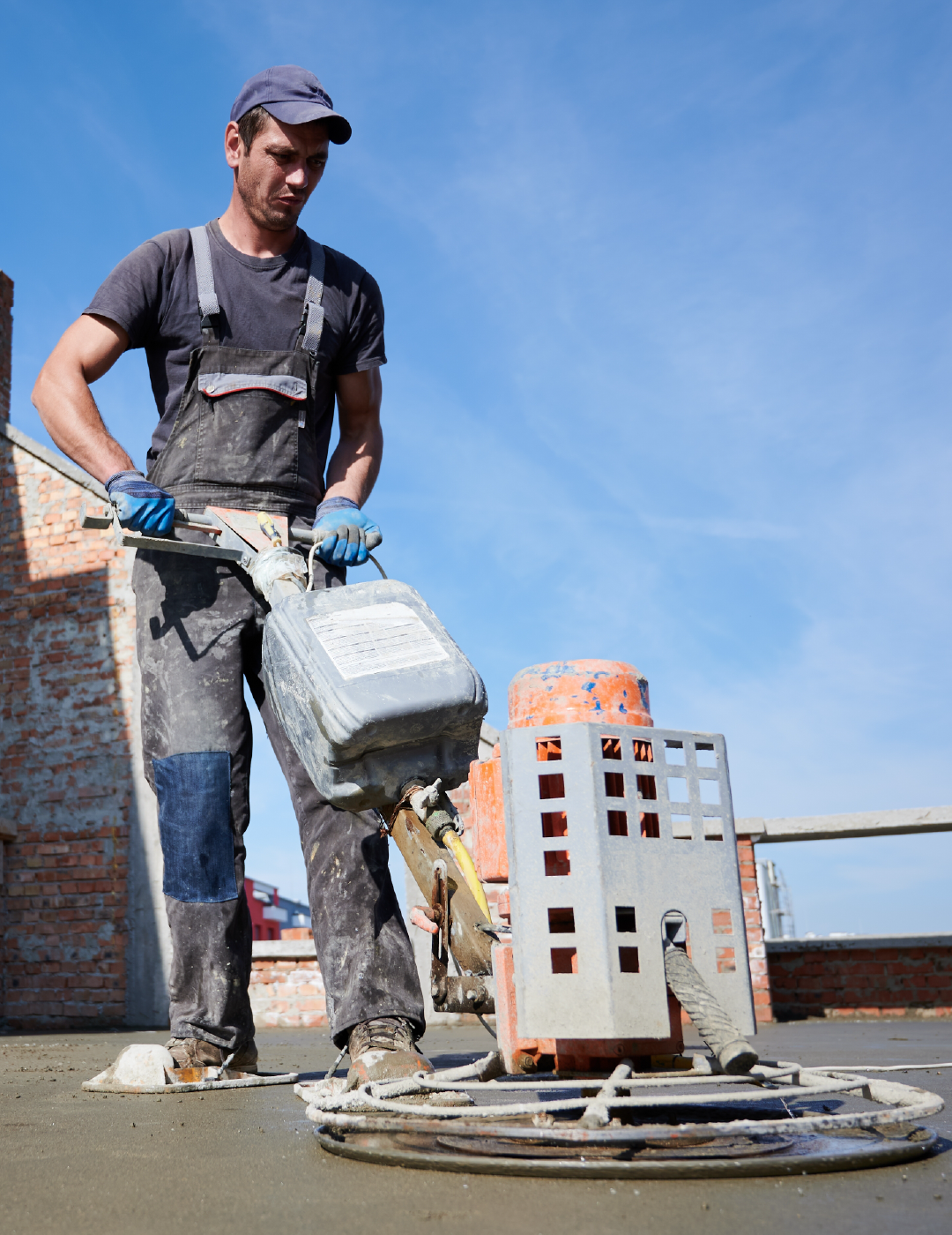 A man is working on a concrete floor with a machine.