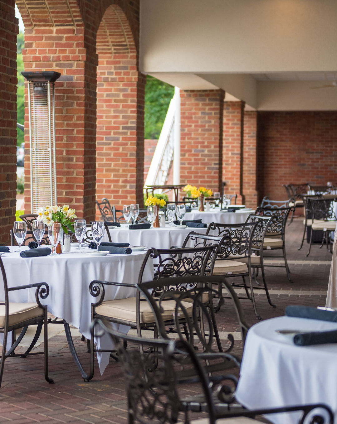 A restaurant with tables and chairs set up for a wedding reception.