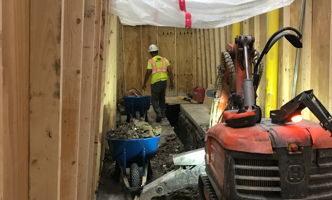 A construction worker is digging a hole in a building.