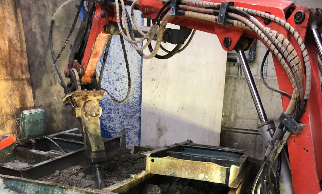 A machine is cutting a piece of metal in a factory.